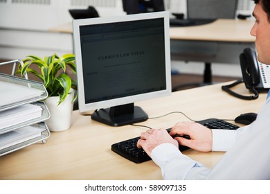 Office Worker Using Computer To Update Resume