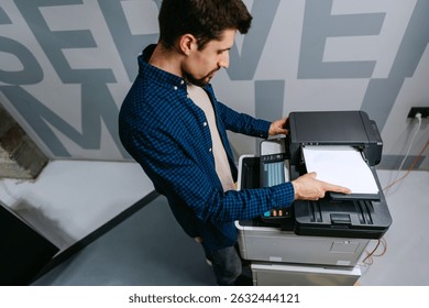 Office worker using a multifunction printer to print documents in a modern workspace