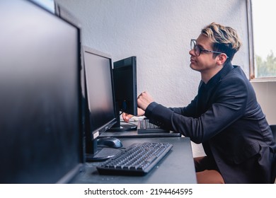 Office Worker Working Hard On His Computer. Office Full Of Computers. Programmer Working On His Computer. Elegant Blonde Caucasian Man Working At A Desk. High Quality Photo