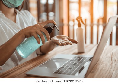 Office Worker Working From Home During Coronavirus Outbreak Cleaning Her Hands With Sanitizer Gel And Wearing Protective Mask. Coronavirus, Covid-19, Work From Home (WFH), Social Distancing Concept.