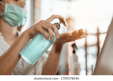 Office Worker Working From Home During Coronavirus Outbreak Cleaning Her Hands With Sanitizer Gel And Wearing Protective Mask. Coronavirus, Covid-19, Work From Home (WFH), Social Distancing Concept.