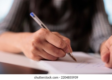 Office Worker Writing Information On Notebook, Taking Notes About Business Report On Textbook At Home. Working On Startup Paperwork And Attending Online Class Webinar On Computer. Close Up.