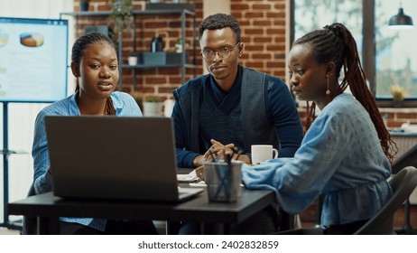 Office workers planning business project, talking about solutions to increase company profit. Modern partners collaborating to create research presentation with annual reports and data analytics. - Powered by Shutterstock