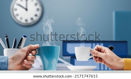 Office workers taking a break during work hours, they are drinking coffee together
