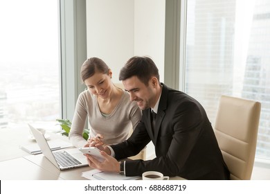 Office workers using digital tablet and laptop sitting at desk, colleagues happy to work with company-issued devices, mobile solutions for business management system, apps for enterprise optimization