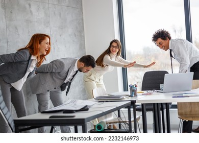 Office workers workout during coffee break. They try to exercise and practice yoga to relax before working day. - Shutterstock ID 2232146973