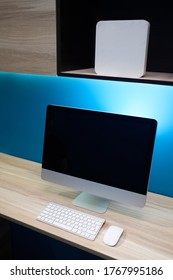 Office workplace with computer. Modern creative workspace on blue wall.
