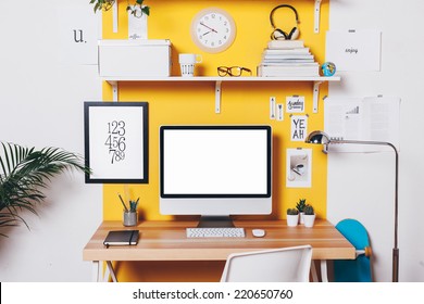 Office workplace with computer./ Modern creative workspace on yellow wall. 