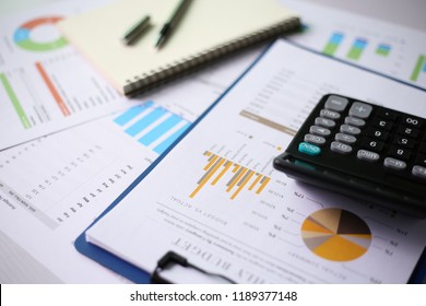 Office workplace with finance charts and calculator on table of office. - Shutterstock ID 1189377148