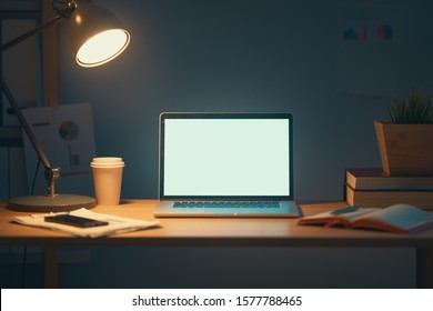 Office Workplace With Laptop On Wooden Table At Night.                               