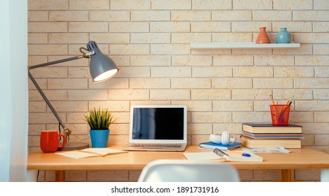 Arbeitsplatz mit Laptop auf Holztisch.                               