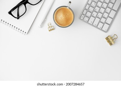 Office Workspace. Black Glasses, Notepad, Cup Of Coffee, Pen, Keyboard And Binder Paper Clip On White Background. Work From Home Business Concept. Blogger Desk. Copy Space For Text, Flat Lay, Top View