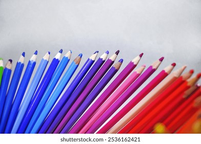 office, writing materials. blue and violet red colored pencils for drawing in a row on a gray background. Using pencils for creativity - Powered by Shutterstock