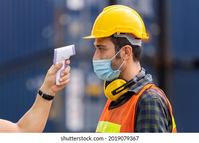 Officer checking fever team engineer and technician foreman with digital thermometer in cargo container shipping. Prevent the outbreak of virus covid-19.