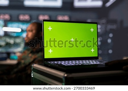 Officer in command post gathering information on enemy troops using mockup laptop. Intelligence corps unit doing assessment of adversaries vulnerabilities with chroma key notebook