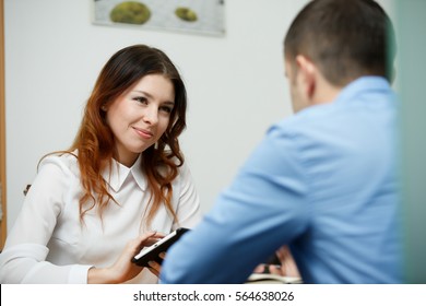 Officeworkers discuss topic with tablet