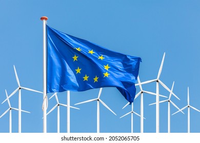 Official flag of the European Union in front of a large windpark with wind turbines