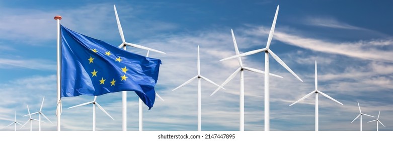 Official flag of the European Union in front of a large windpark with wind turbines - Shutterstock ID 2147447895