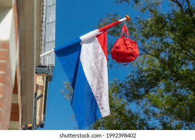 Official Netherlands flag with a school bag hanging out side the house along the street, A tradition way in Holland when a student celebrate their graduates or Geslaagd in Dutch word.