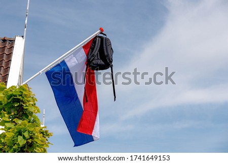 Official Netherlands flag with a school bag hanging out side the house, A tradition way in Holland when a student celebrate their graduates or Geslaagd in Dutch word.