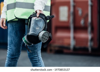 Officials From Department Of Hazardous Substances Control Bureau Is Investigating  Leak Of A Hazardous Chemical At Wearhouse Container. Caucasian Woman Working And Holding Gas Mask