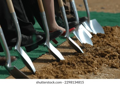 Officials shoes during a ground-breaking ceremony with shovels in the dirt.