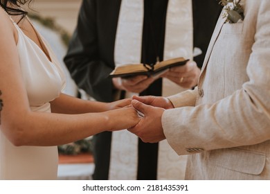 Officiant And Couple Reading Bible