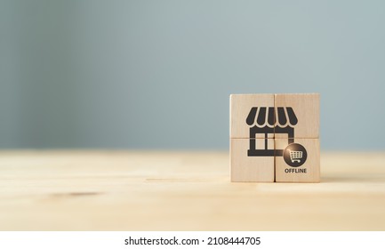 Offline shopping and offline marketing concept. The wooden cubes with shop and offline purchasing icons on grey background and copy space. Marketing and sales channel strategy for product, service.