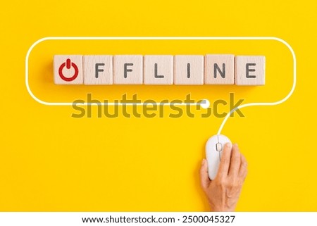 offline text with red closed button instead of O on wooden cube block with hand using computer mouse on yellow background