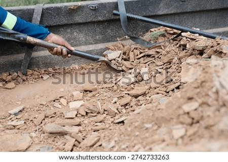 Offloading gravel and rocks from he back of a truck using a shovel