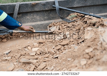 Offloading gravel and rocks from he back of a truck using a shovel