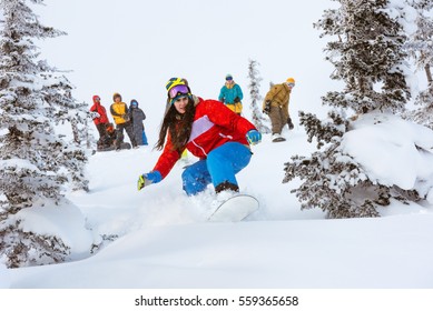 Off-piste Snowboarding. Girl Freeriding In Forest With Group Of Friends