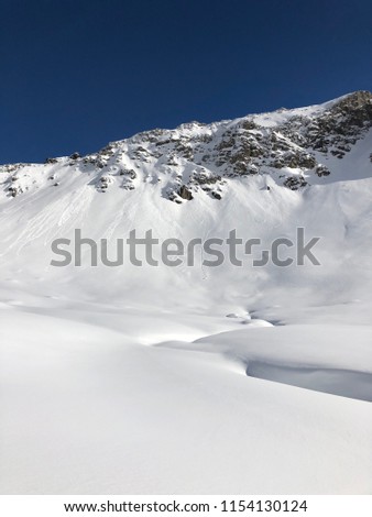 Offpiste views of mountains and skiiers in Klosters, Switzerland near Davos