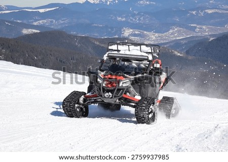 off-road buggy driving fast on a snowy mountain slope with dramatic winter landscape in the background. action shot with snow spray, rugged terrain, and scenic mountains, representing adventure, extreme sports, and outdoor travel