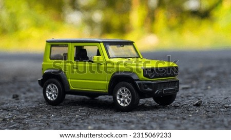 Off-road car with a green highlighter ready to explore even on an asphalt road with a green forest as a background