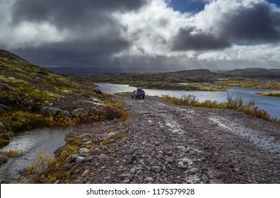 Off-road Car On The Stoned Road In The Tundra At Rain Weather