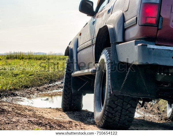 Off-Road Car is riding on a\
dirt road.