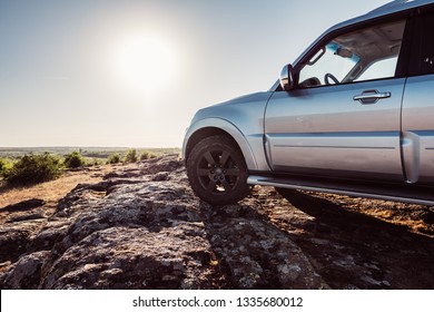 Off-road Car Is Standing On Rocky Mountain Road. Outdoor, Adventures And Travel Suv. Expedition, Explore Wheels On Summer Path Way. Car Tyre Tracks On Countryside Nature Landscape Stones.