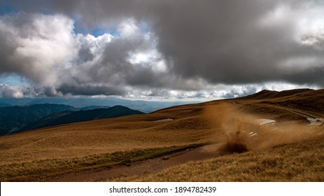 Offroad Extreme Car Splash In Muddy Water With Beautiful Mountain Landscape In The Background And Dramatic Sky