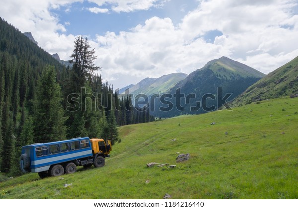 Off-road\
passenger truck on mountains\
background.