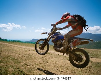 Off-road rider is jumping against a summer mountains