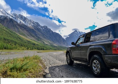 Off-road SUV car with Aktru mountain valley and glacier background. Adventure travel concept. Adventure tourism. Nature landscape. Overland 4x4 journey concept.