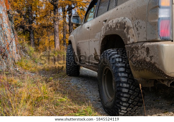 Offroad suv on gravel road in autumn forest.\
Autumn mountain road landscape. Autumn forest road landscape.\
22.09.2020 Katon,\
Kazakhstan.