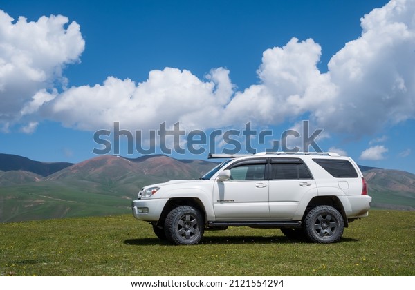 Off-road SUV Toyota 4runner with mountains\
and cloudy sky background. Offroad journey, tourism concept. Assy\
plateau in spring season. Overlander off-road expedition.\
06.06.2021 Almaty,\
Kazakhstan.