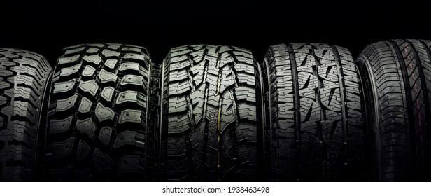 off-road tires and tires for crossovers and SUVs stand in a row on a black background
