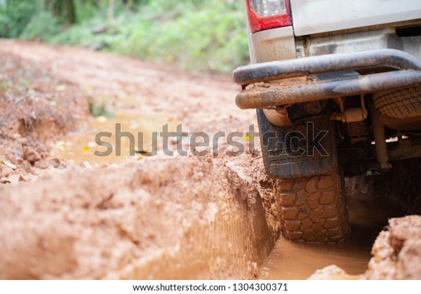 Off-road tires,\
Dirty offroad car, SUV covered with mud on countryside road. \
offroad travel  and driving\
concept.