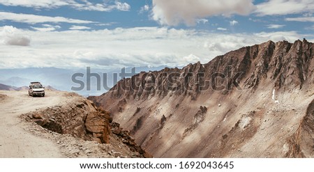 Off-road vehicle auto going through high altitude Mountain pass on Leh - Manali road in Northern Indian Himalaya, Ladakh region.