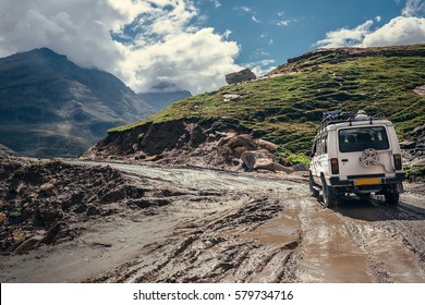 Off-road vehicle goes on the mountain way during the rainy season