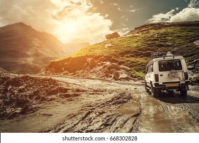 Off-road vehicle goes on the mountain way during the rainy season - Shutterstock ID 668302828