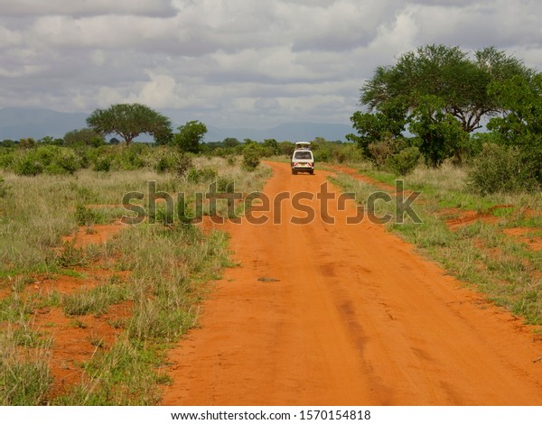 Off-road vehicle on dirt road at Tsavo East\
National Park, Kenya,\
Africa